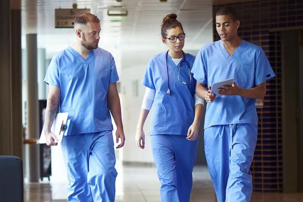 Three residents having a discussion as they walk.