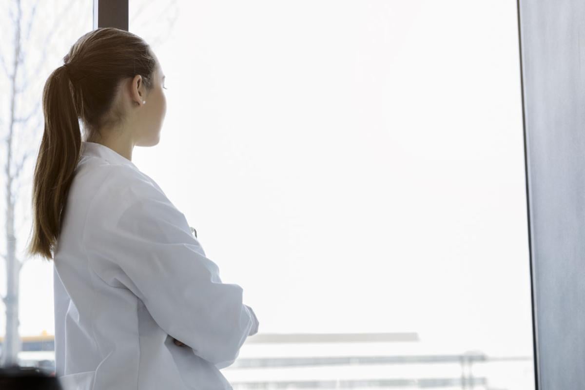 Woman physician looking out the window