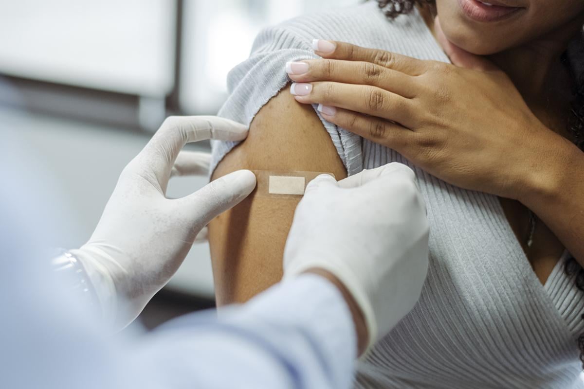 Physician applying a bandage on a patient's arm