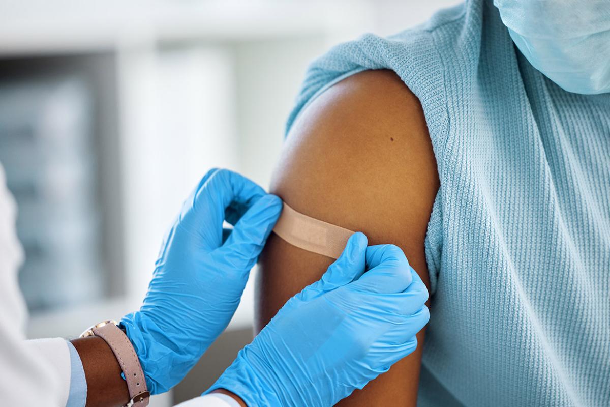 Health care worker applying bandage to patient's arm