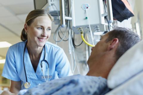 Physician checking in on patient in bed