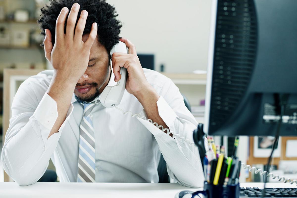 Person on the phone with head in hand