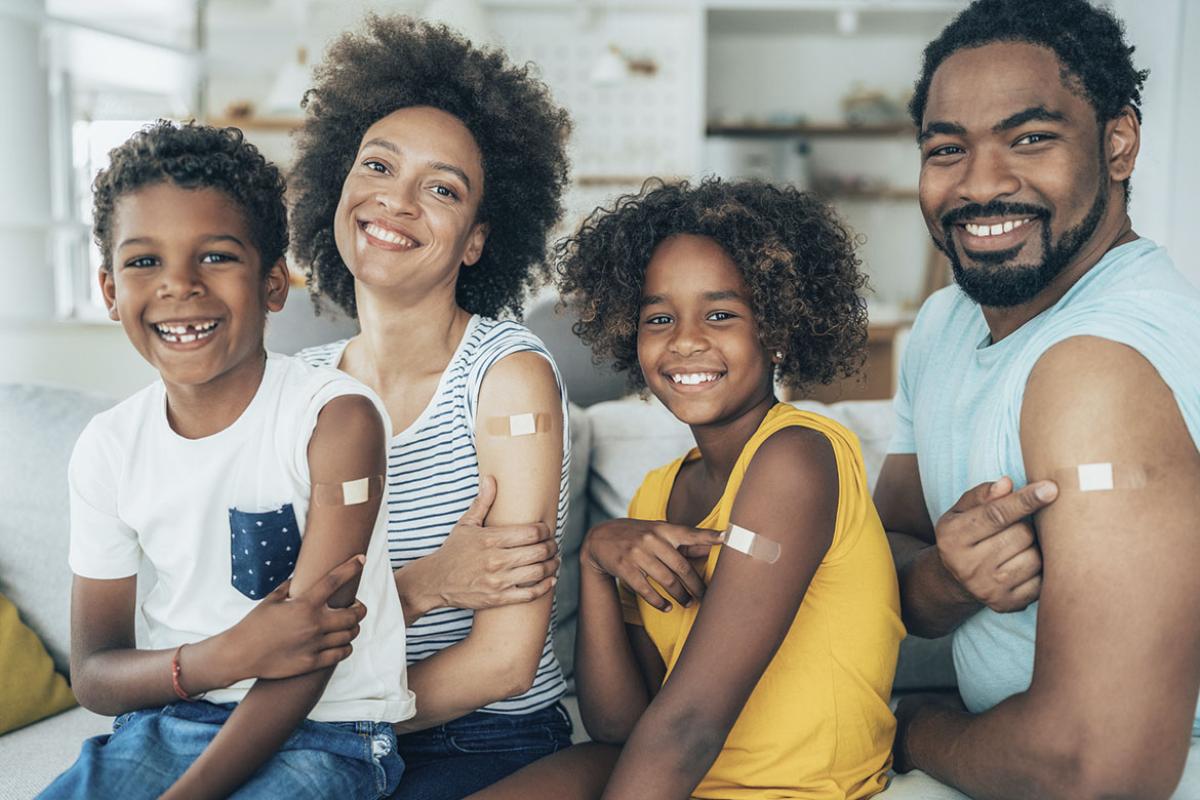 Smiling family with bandages on their upper arms