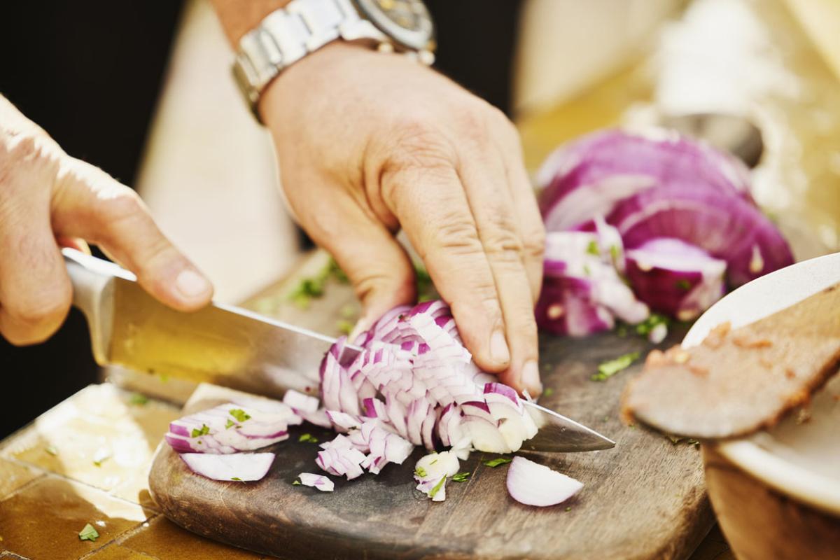 Hands cutting an onion