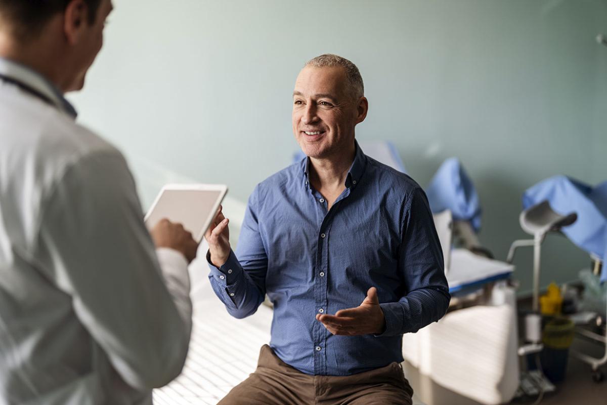 Doctor with male patient using digital tablet 